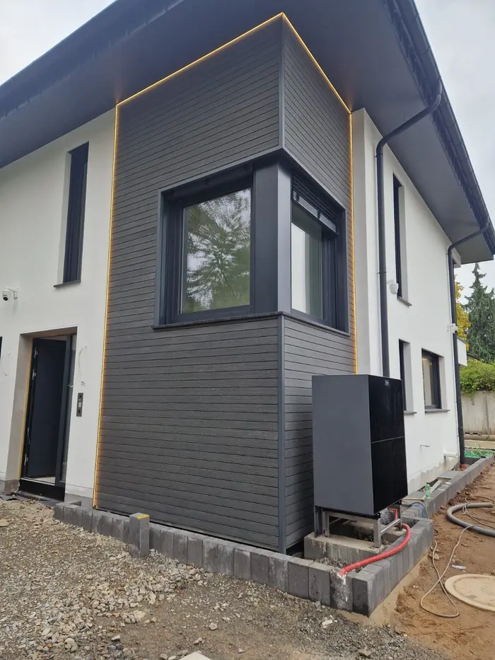Fassade mit LED-Lichtkante, daneben die Wärmepumpe