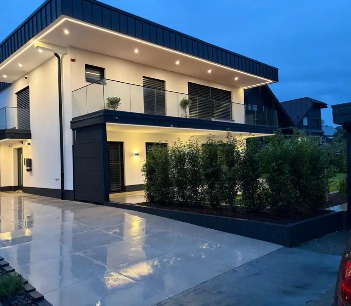 Fertiges Einfamilienhaus am Abend: LED-Lichtkanten, Downlights und Wandleuchten